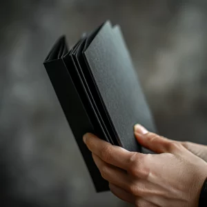 Mano sosteniendo un portafolio negro con textura suave, representando soluciones profesionales de merchandising